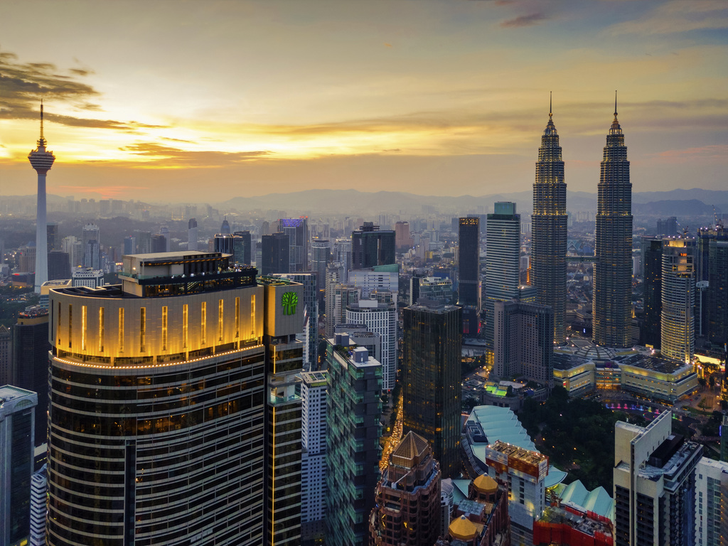 Kuala Lumpur skyline at sunset with the Petronas Twin Towers and KL Tower