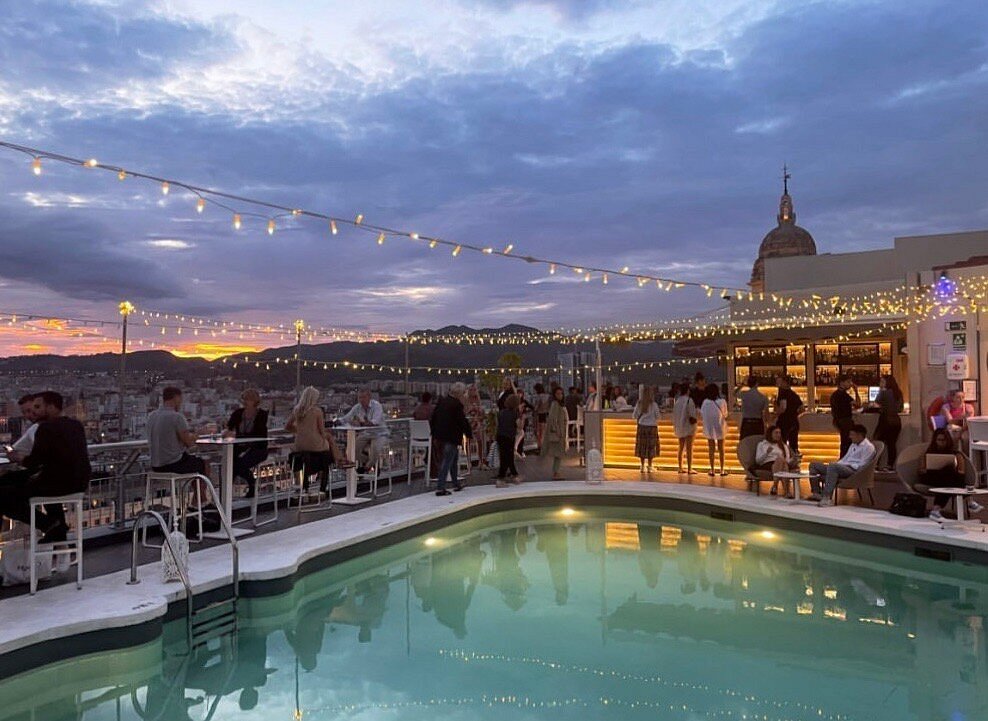 Rooftop pool bar at Hotel Málaga Palacio at dusk
